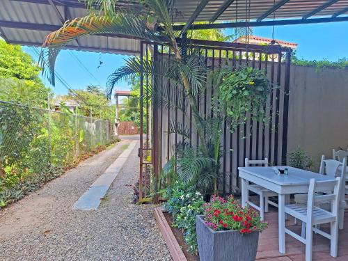 a patio with a table and some plants and a fence at Infiniti Hotel in Puerto Viejo