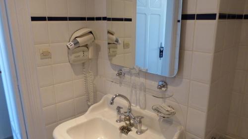 a bathroom with a sink and a mirror at Hotel De L'Europe in Toul