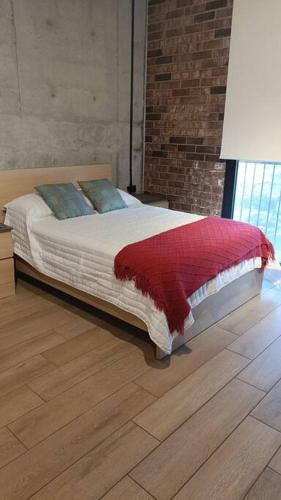 a bedroom with a bed with a red blanket on it at Premier Monterrey Retreat 5 in Monterrey