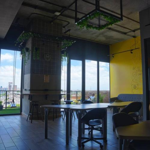 a restaurant with tables and chairs in a room with windows at Premier Monterrey Retreat 5 in Monterrey