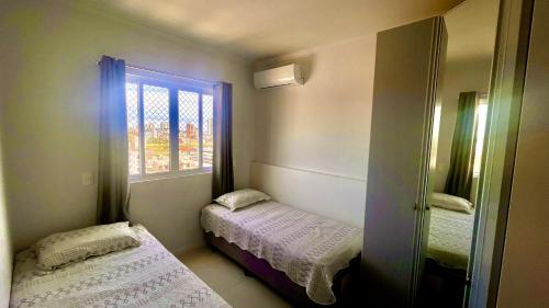 ein kleines Zimmer mit zwei Betten und einem Fenster in der Unterkunft Apto Home Club 500m Praia Piçarras 20 min Beto Carrero - ANG905C in Piçarras