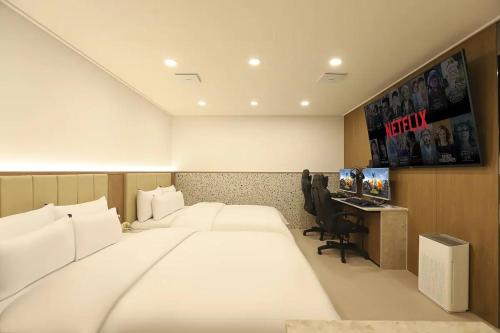 a hotel room with a large bed and a desk at Rosy Hotel in Cheongju