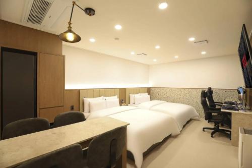 a hotel room with a large bed and a desk at Rosy Hotel in Cheongju