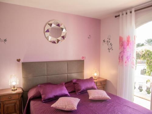 - une chambre avec un lit violet et 2 oreillers dans l'établissement Villa Nycou, à Bagnols-en-Forêt
