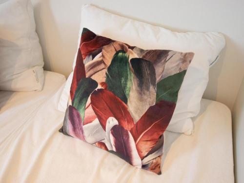 a pillow with a painting of flowers on a bed at Grote Karekiet 24-22 in Nieuwersluis