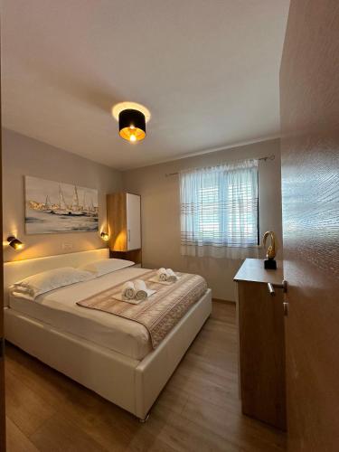 a bedroom with a large bed and a window at Family-friendly apartments with swimming pool Promajna, Makarska - 6849 in Promajna