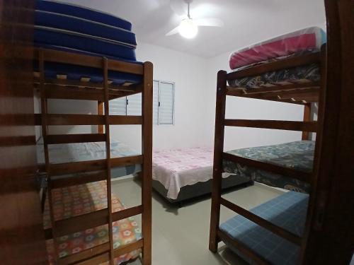 a room with two bunk beds and a small bed at Casa Cibratel 2 in Itanhaém