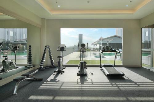 a gym with cardio equipment and a large window at Swiss-Belinn Saripetojo Solo in Solo