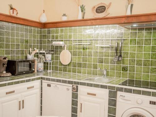 Il dispose d'une cuisine carrelée avec un évier et un four micro-ondes. dans l'établissement Villa Nycou, à Bagnols-en-Forêt