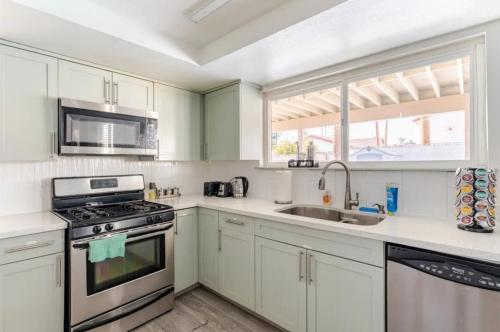 a kitchen with white cabinets and a stove and a sink at Oasis in the desert with huge heated Pool and SPA in Las Vegas