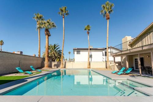 a swimming pool with blue chairs and palm trees at Oasis in the desert with huge heated Pool and SPA in Las Vegas