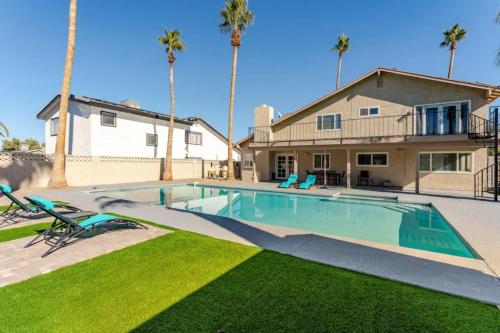 a swimming pool in front of a house with palm trees at Oasis in the desert with huge heated Pool and SPA in Las Vegas