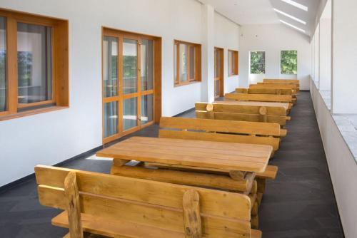 a row of wooden benches in a classroom at Pensiunea Art 1000 in Lunca Vişagului