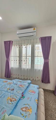 a bedroom with purple curtains and a large bed at Pani House Hatyai 5 in Hat Yai