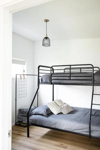 a bedroom with two bunk beds in a room at Orion Beach Cottage B - Jervis Bay in Vincentia