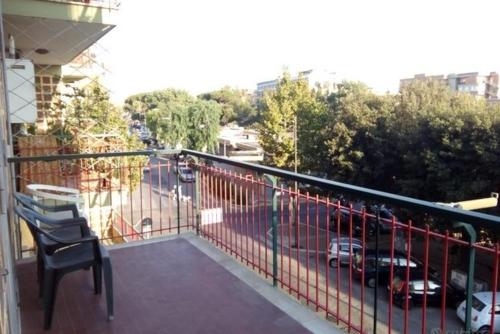 a balcony with a chair and a view of a street at Appartamento - Ladispoli in Ladispoli