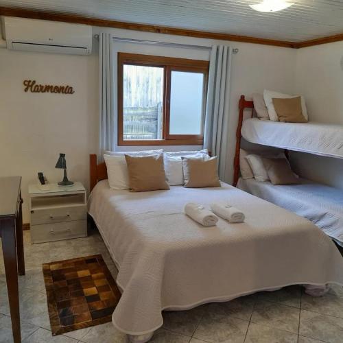 a bedroom with two beds and a window at Hospedaria Paradouro Caracol in Canela