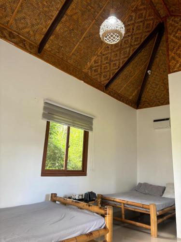 a bedroom with two beds and a window at Camelo Farm in Bilar
