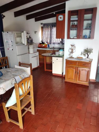 a kitchen with a table and a kitchen with a refrigerator at bungalows in Santa Rosa