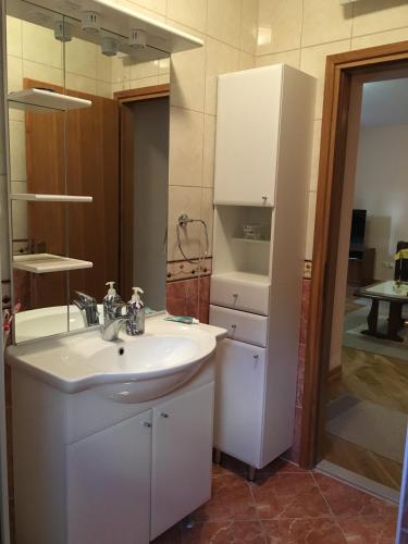 a bathroom with a white sink and a mirror at Apartment Sanja in Baška Voda