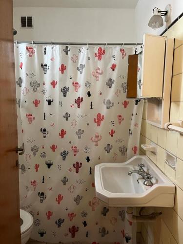 a bathroom with a shower curtain and a sink at Depto Avenida Colón-Mar del Plata in Mar del Plata