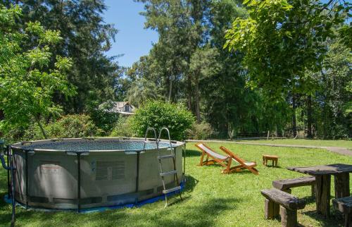 una vasca idromassaggio sull'erba con tavolo da picnic e panchine di Quinta isleña Las Marías - Pileta - Domingos Check out 17 hs a Tigre