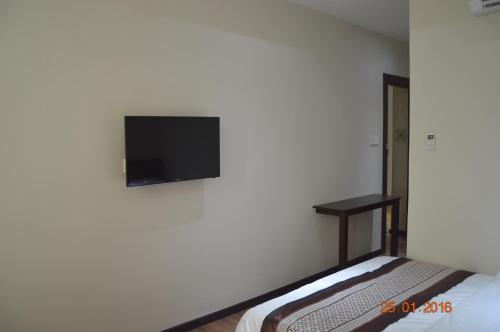 a bedroom with a flat screen tv on the wall at Qu Lin Resident in Sibu