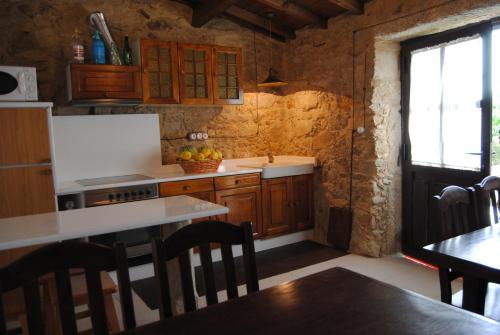 cocina con armarios de madera, mesa y ventana en Casa Carola, en Oia