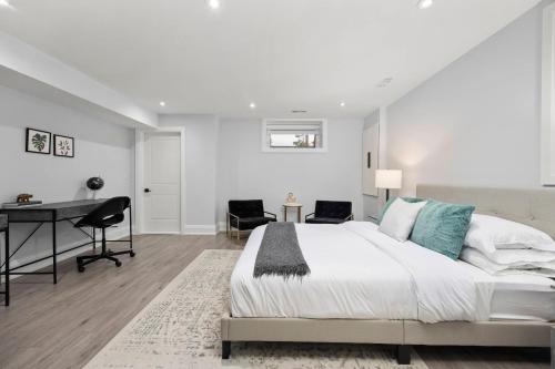 a white bedroom with a bed and a desk at Modern Home Pool Still Open Two Fire Pits Free Parking Game Room in Toronto