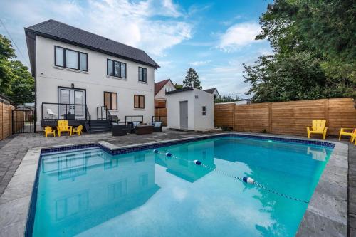 a swimming pool in front of a house at Modern Home Pool Still Open Two Fire Pits Free Parking Game Room in Toronto