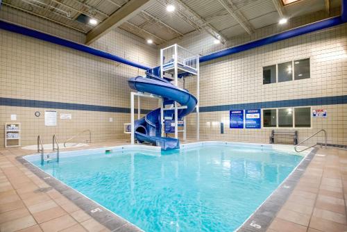 a swimming pool with a blue slide in a building at Coast Osoyoos Beach Hotel in Osoyoos