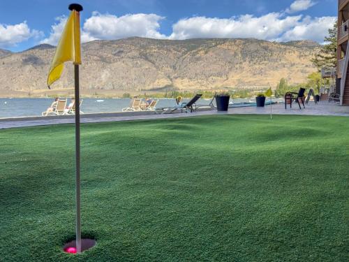 a putting green with a yellow flag in the grass at Coast Osoyoos Beach Hotel in Osoyoos