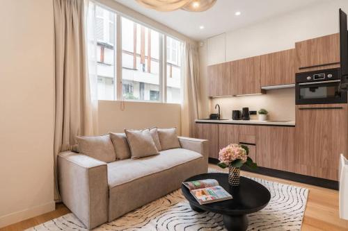 un salon avec un canapé et une table dans l'établissement Splendide appartement de luxe Saint-Germain, à Paris