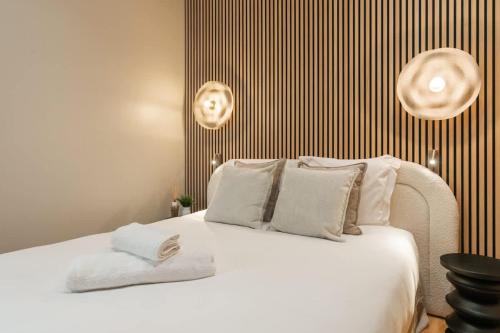 une chambre avec un lit blanc avec deux serviettes dessus dans l'établissement Splendide appartement de luxe Saint-Germain, à Paris