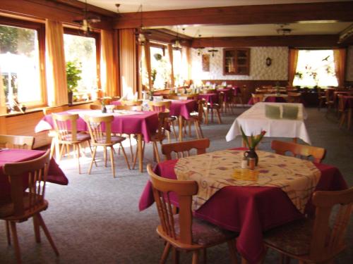 ein Restaurant mit Tischen und Stühlen mit lila Tischtuch in der Unterkunft Jägerhof Kropfmühle in Seewald