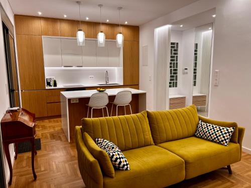 a living room with a yellow couch and a kitchen at Stunning View Zeas Marina - 2 bedrooms in Piraeus