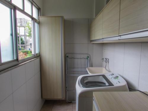 a small bathroom with a sink and a washing machine at APARTAMENTO TRiNDADE in Manaus