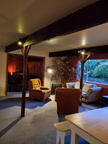 a living room with couches and chairs and a table at Howard's Mountain Lodge in National Park