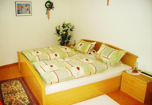 ein Schlafzimmer mit einem Holzbett mit Kissen darauf in der Unterkunft Ferienwohnung Kappauf / Petrik in Friedenfels