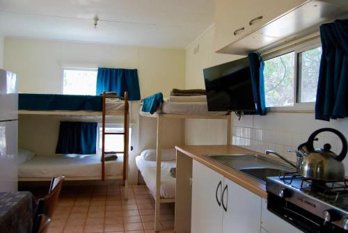 a kitchen with two bunk beds in a room at Coral Coast Tourist Park in Carnarvon