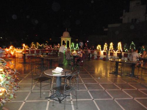 un patio avec des tables et des chaises la nuit et des lumières dans l'établissement Krishna Palace - A Heritage Boutique Hotel, à Jaipur