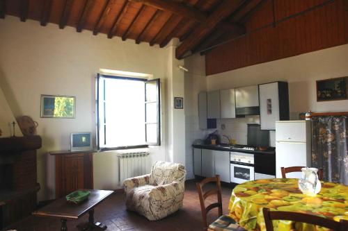 a living room with a table and a kitchen at Tenuta Il Tresto in Poggibonsi