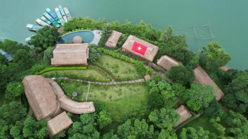 a model of a house on a island in the water at Mai Chau Hideaway Lake Resort in Mai Chau