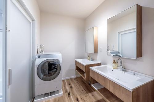 a bathroom with two sinks and a washing machine at Apartment Hotel 11 Villa Hanazonocho in Osaka