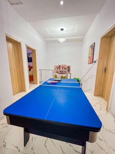 a blue ping pong table in a room at Modern 4-Bedroom Duplex with Home Office Option in Lekki