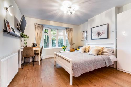 a bedroom with a bed and a desk and a window at Charm Double En-suite Bedroom 3 in Oxford