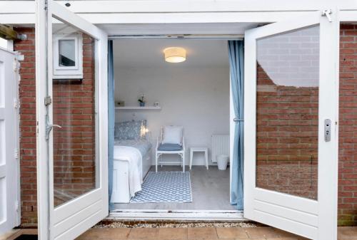 an open door leading to a room with a table at Huisje Bloemenzee in Noordwijkerhout