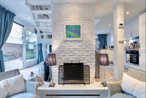 a living room with a fireplace and a stone wall at Huisje Bloemenzee in Noordwijkerhout