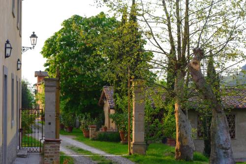 a house with a gate and a tree on a street at Tenuta Il Tresto in Poggibonsi