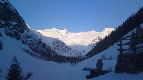 a snow covered mountain with a cabin in the foreground at Panoramablick Osttirol in Lienz